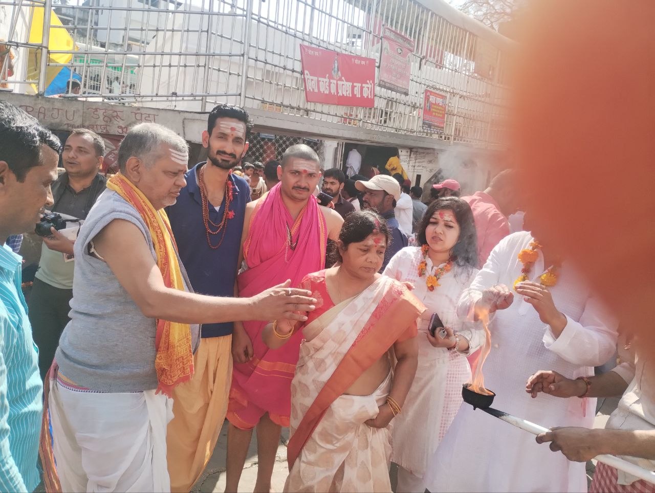 Pujaris and devotees with the aarti flame outside the temple